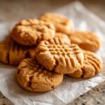 A close-up of a pile of 3 ingredient peanut butter cookies with classic fork marks.